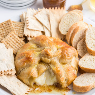 baked brie cut open with oozing cheese and crackers and bread