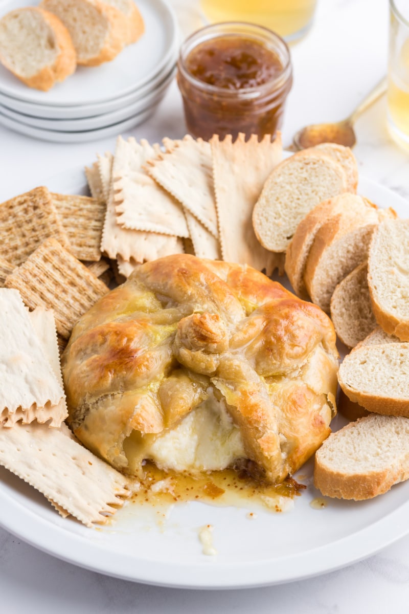 baked brie cut open with oozing cheese and crackers and bread