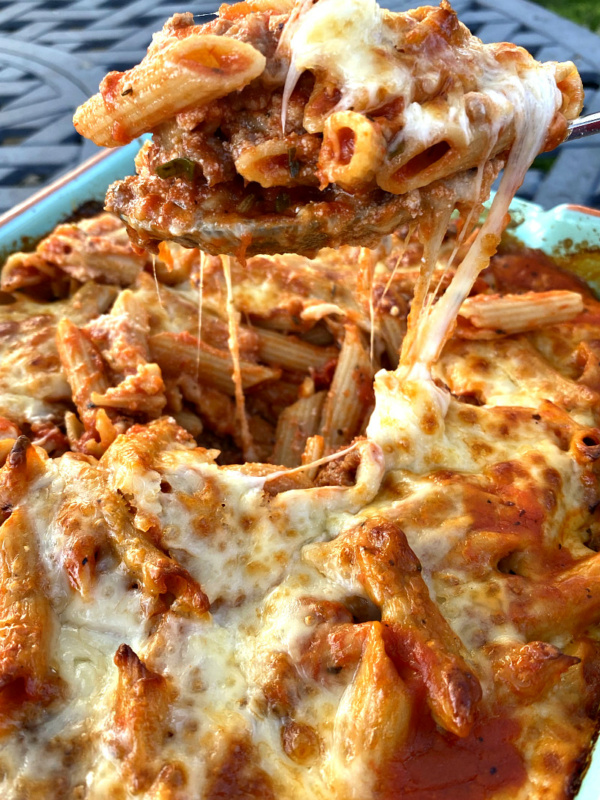 serving spoonful of baked penne with italian sausage