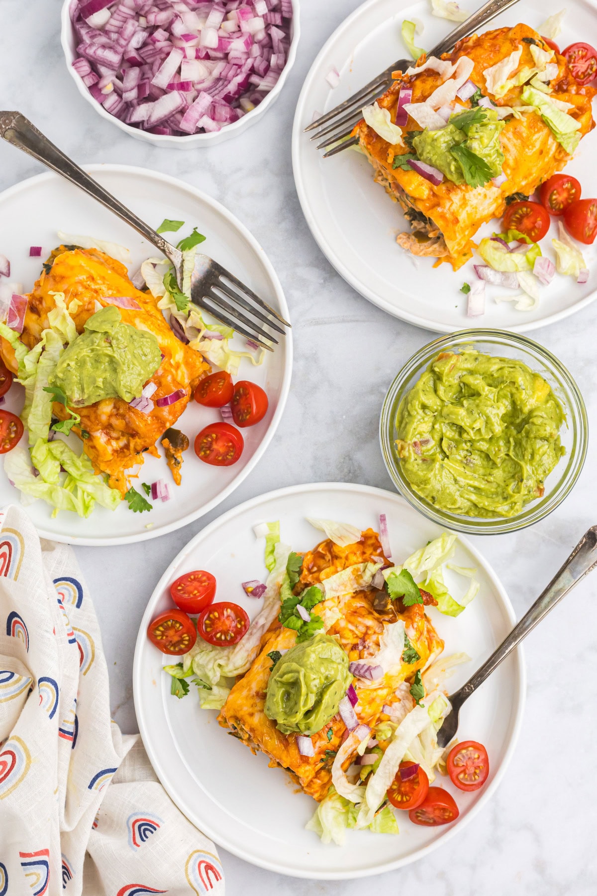 overhead shot of plates of chicken and spinach enchiladas
