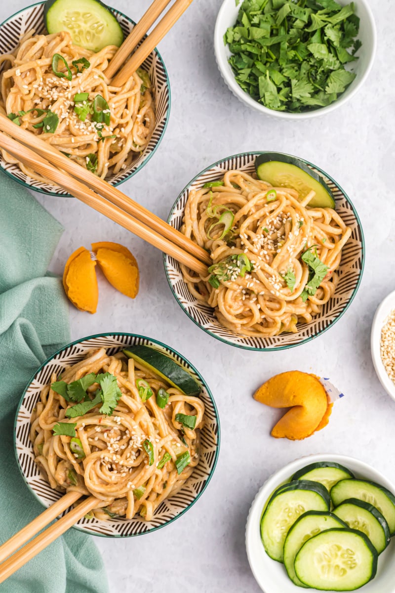 three bowls of cold sesame noodles with chopsticks