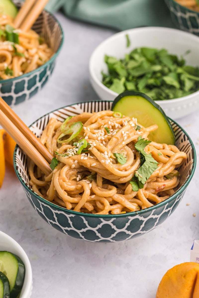 cold sesame noodles in a bowl with chopsticks