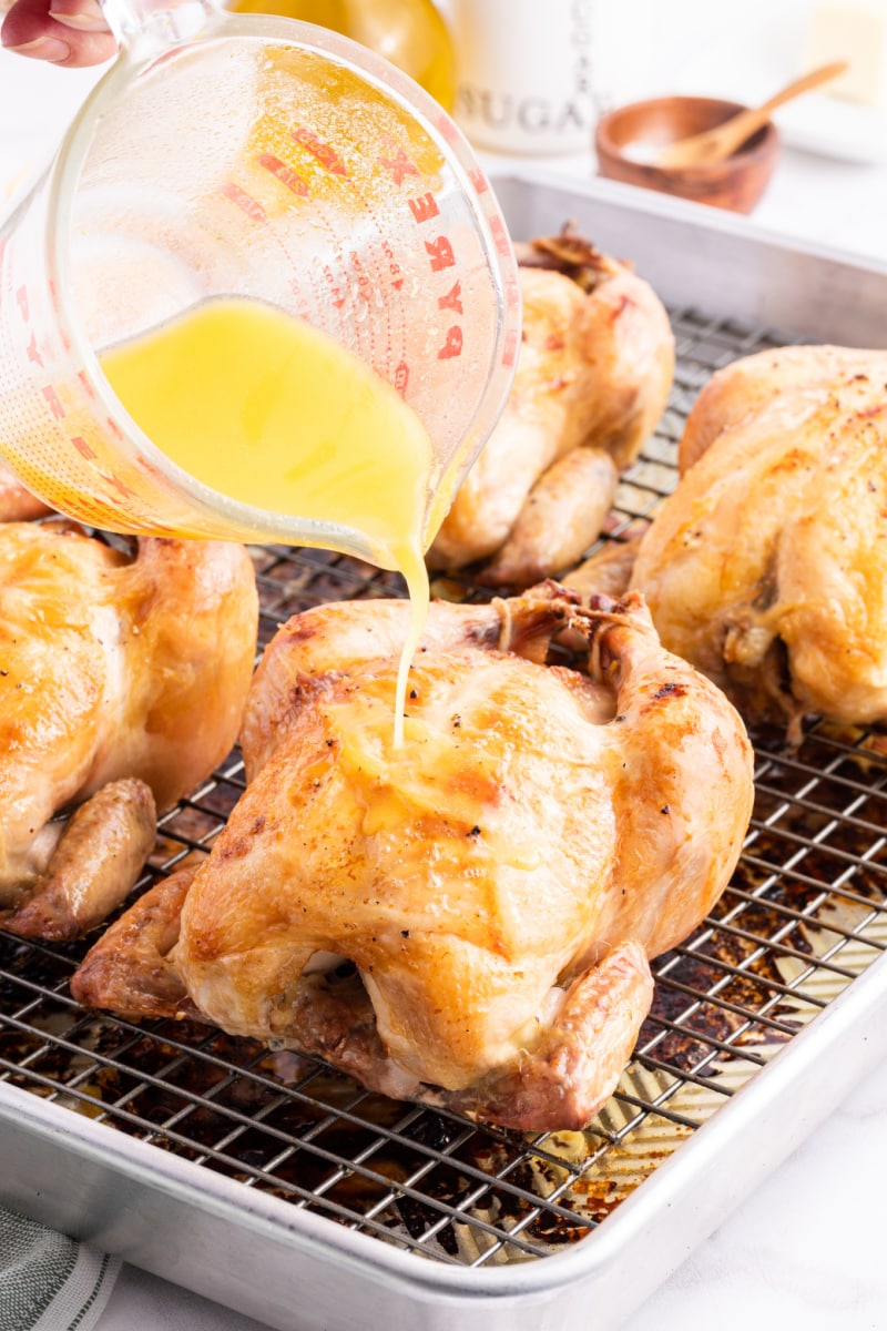 pouring melted butter over cornish hens