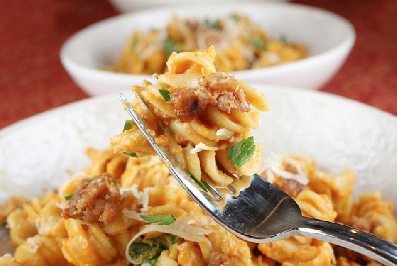 fork of pumpkin pasta over a bowl of it