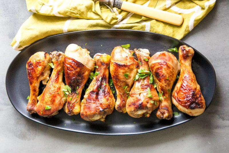 Easy Glazed Chicken Drumsticks recipe from RecipeGirl.com #easy #glazed #baked #chicken #drumsticks #recipe #RecipeGirl Glazed Chicken Drumsticks on a brown oval platter