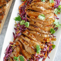 grilled pork tenderloin with hoisin sesame sauce on a white plate