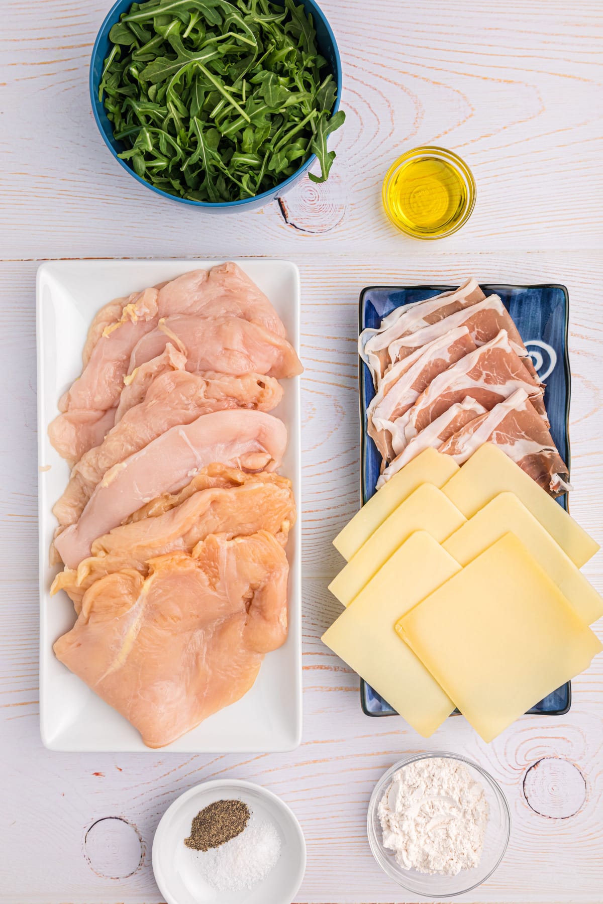 ingredients displayed for making gruyere arugula and prosciutto stuffed chicken breasts