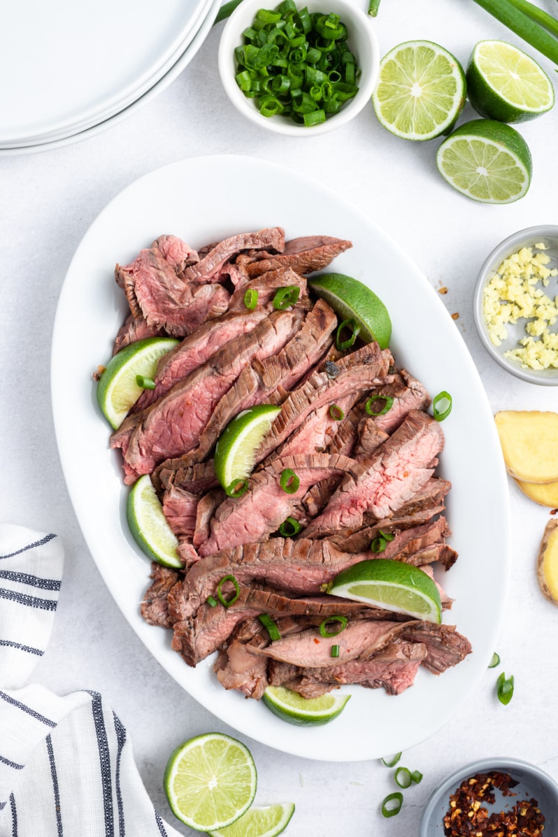 lime marinated flank steak sliced on a platter