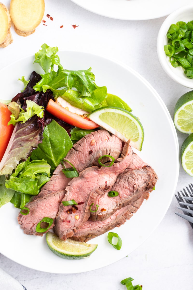 serving of flank steak on a plate with salad