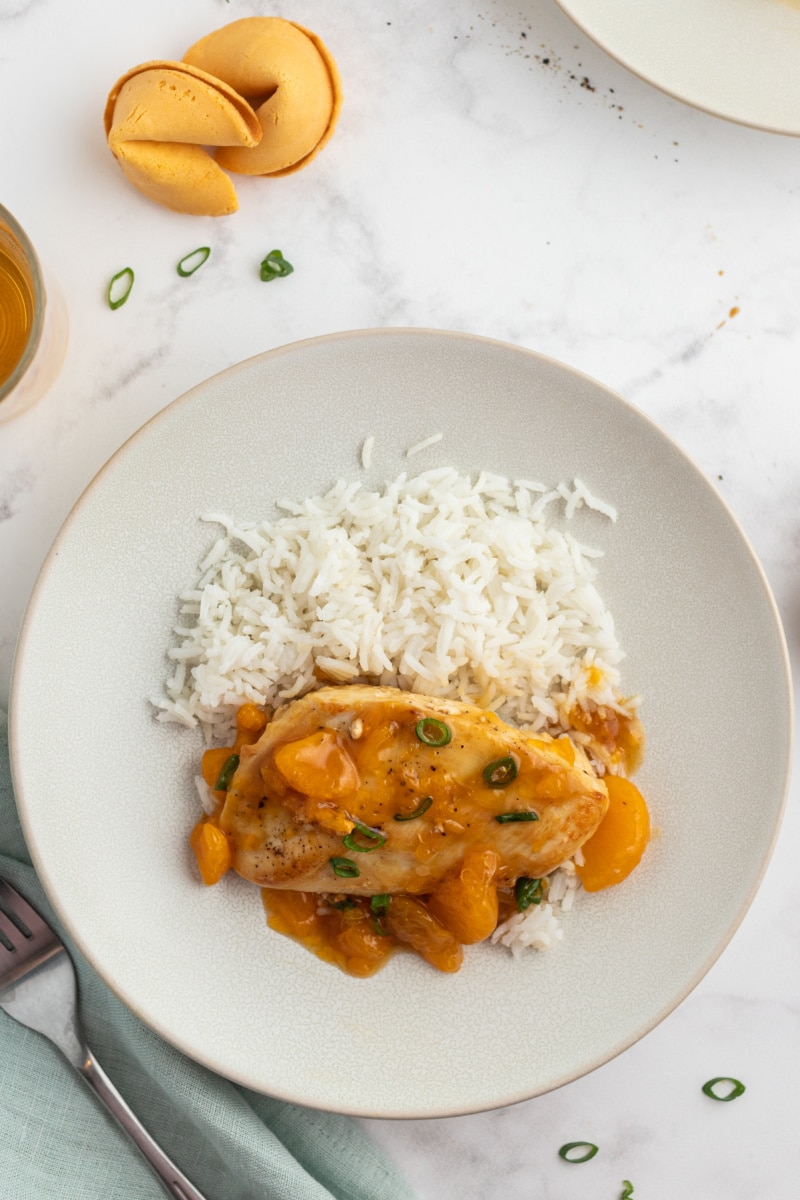 asian orange chicken served on white plate with rice