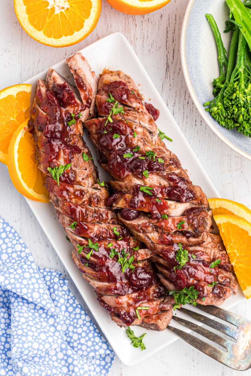 orange cranberry glazed pork tenderloin sliced on a platter