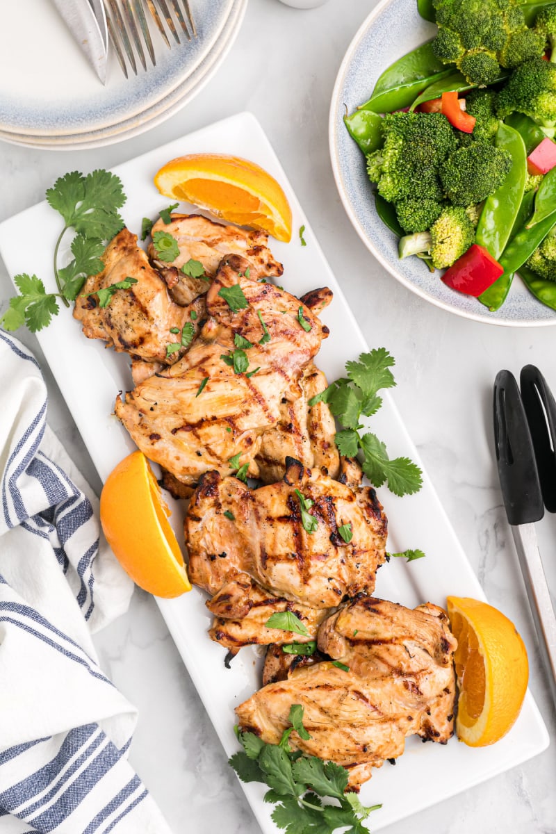 platter of grilled chicken with orange slices