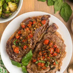 pan seared ribeye steak with balsamic onion and tomato salsa on plate