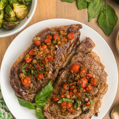 pan seared ribeye steak with balsamic onion and tomato salsa on plate