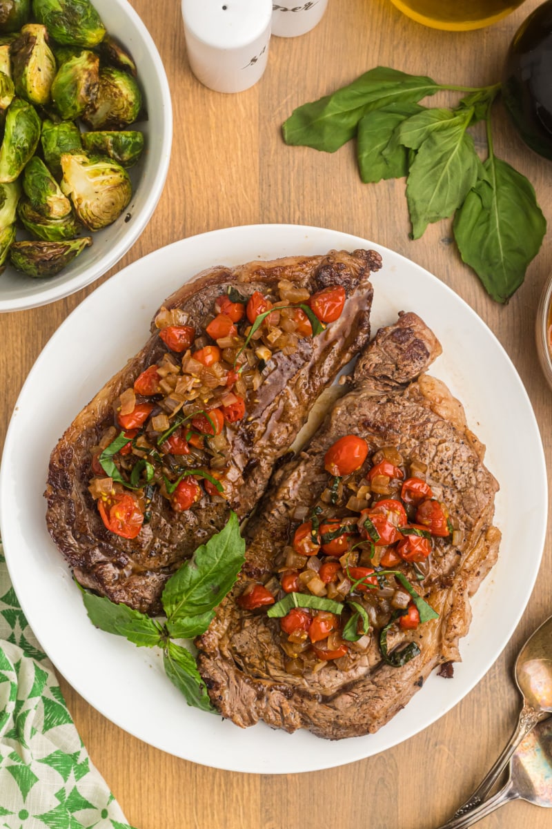 pan seared ribeye steak with balsamic onion and tomato salsa on plate