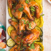 roasted apricot ginger glazed game hens on a platter with veggies