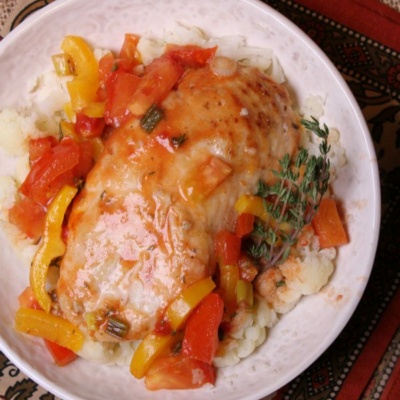 Sauteed chicken with tangy tomato sauce on a white plate