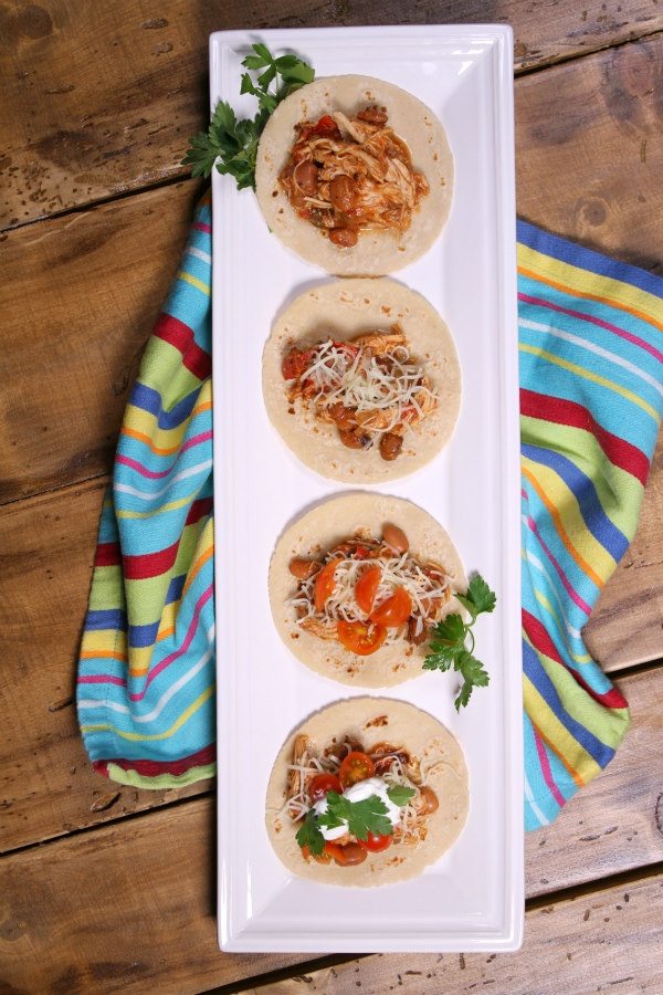 Slow Cooker Tex Mex Chicken and Beans served on tortillas on a white plate