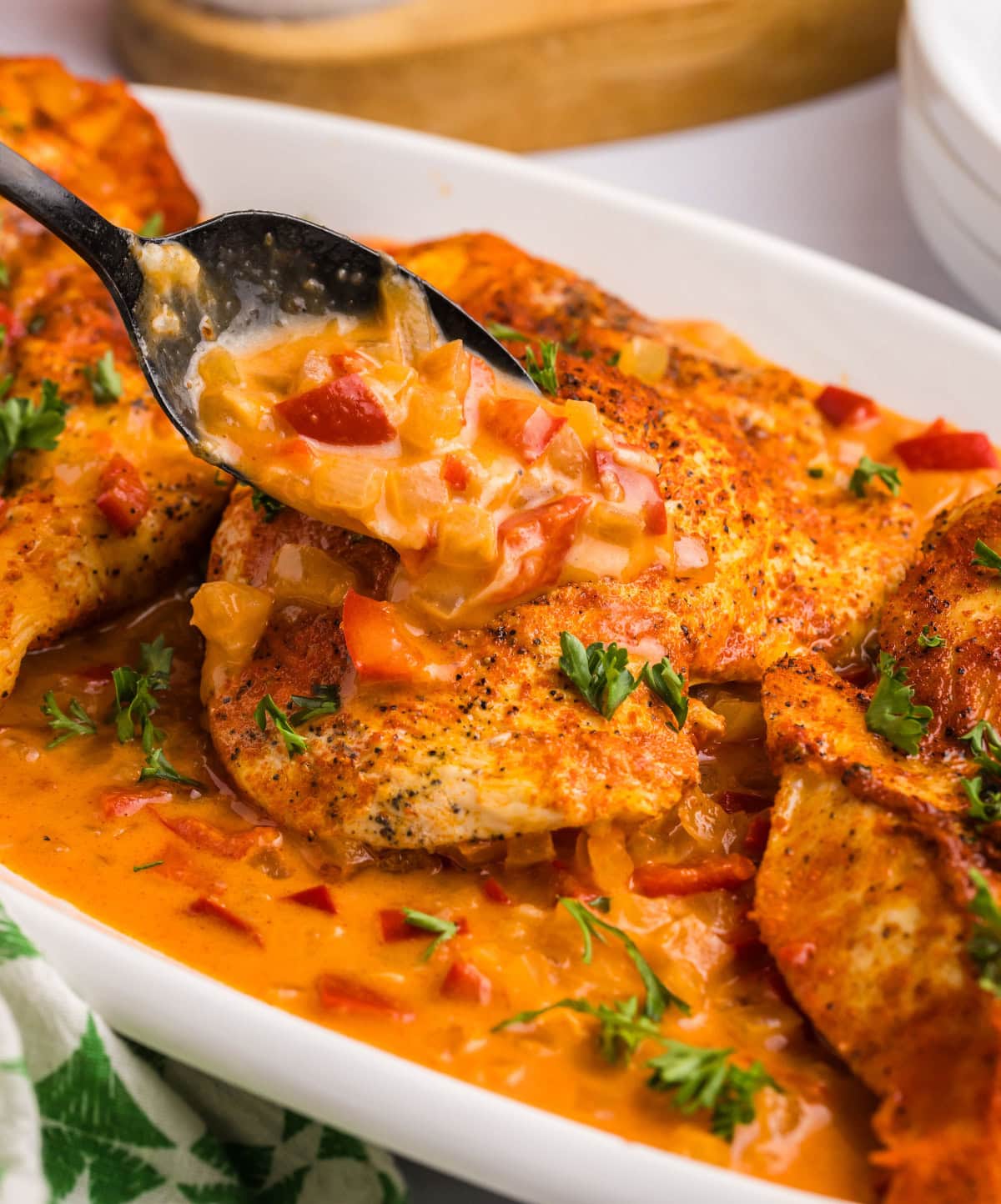 spooning sauce onto smothered chicken