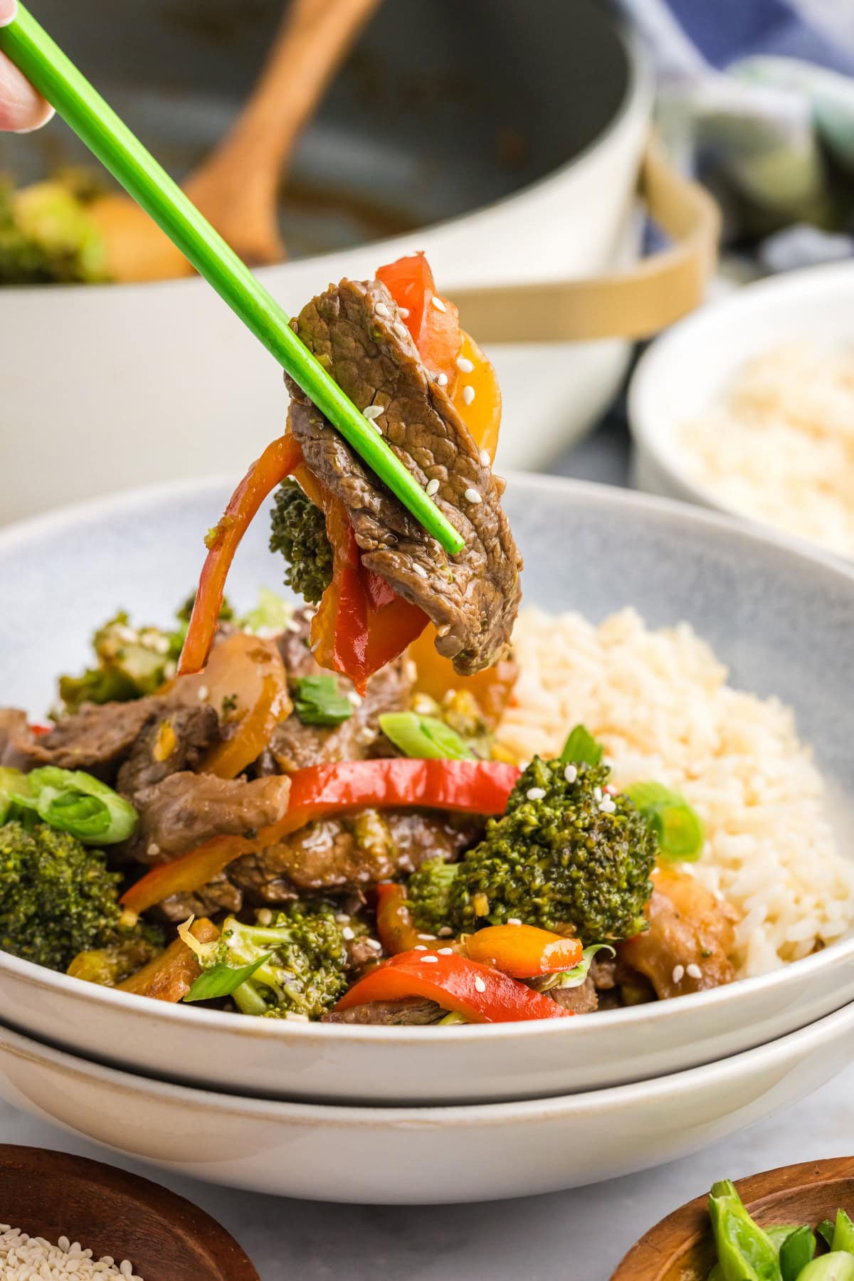 chopsticks holding stir fried beef and broccoli