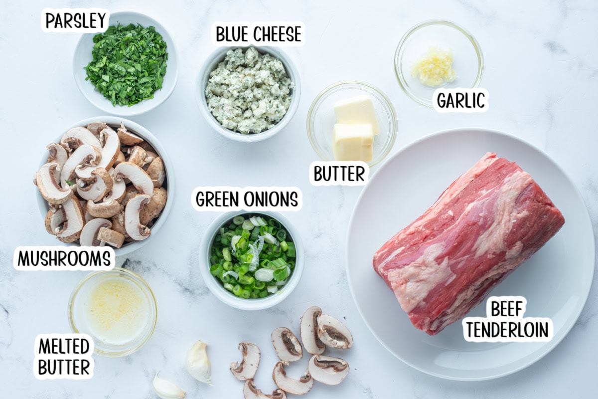 Elegant stuffed beef tenderloin filled with mushrooms, garlic, green onions, and blue cheese. A stunning holiday or special-occasion dinner that’s surprisingly easy! ingredients displayed for making stuffed beef tenderloin