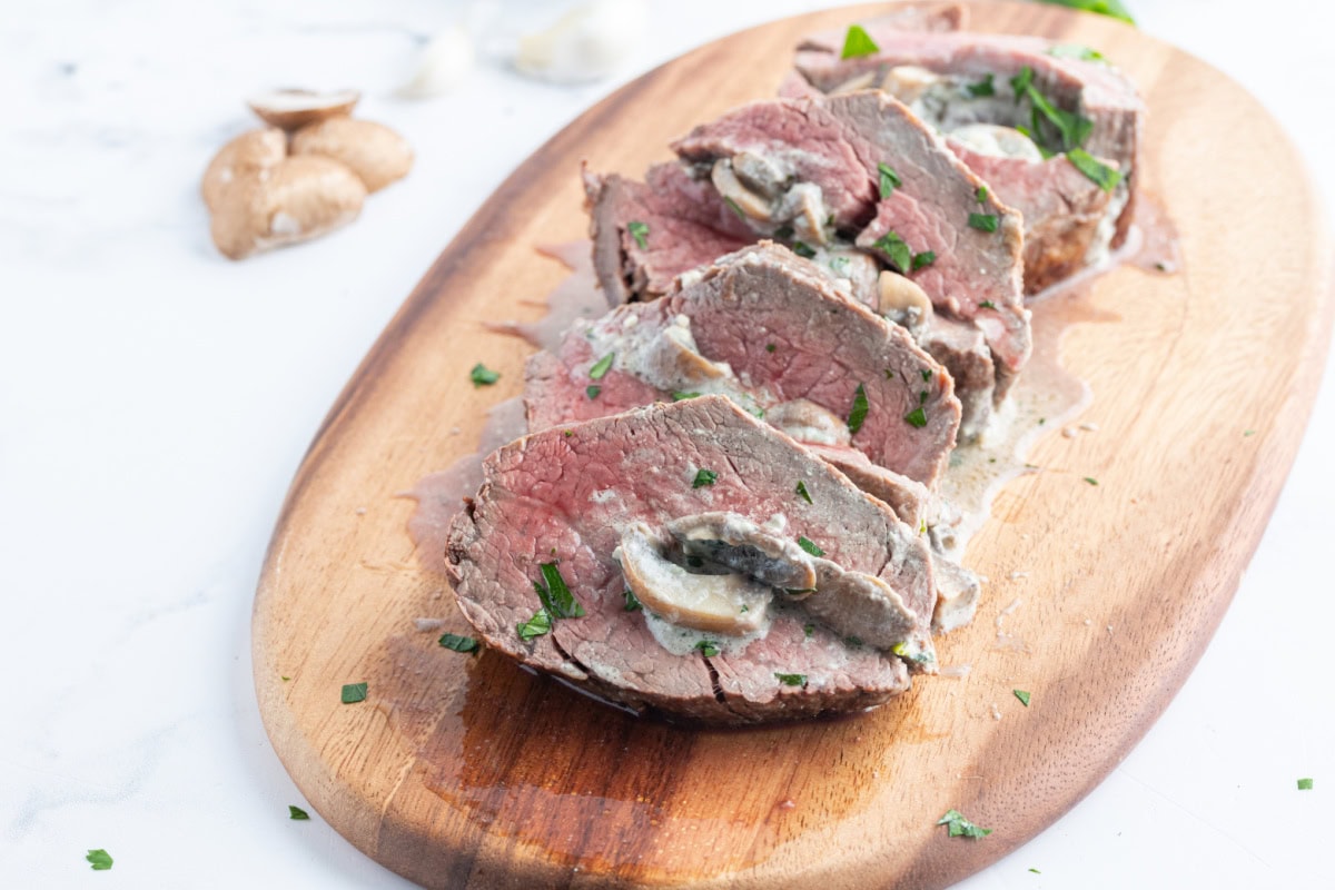 Elegant stuffed beef tenderloin filled with mushrooms, garlic, green onions, and blue cheese. A stunning holiday or special-occasion dinner that’s surprisingly easy! sliced stuffed beef tenderloin