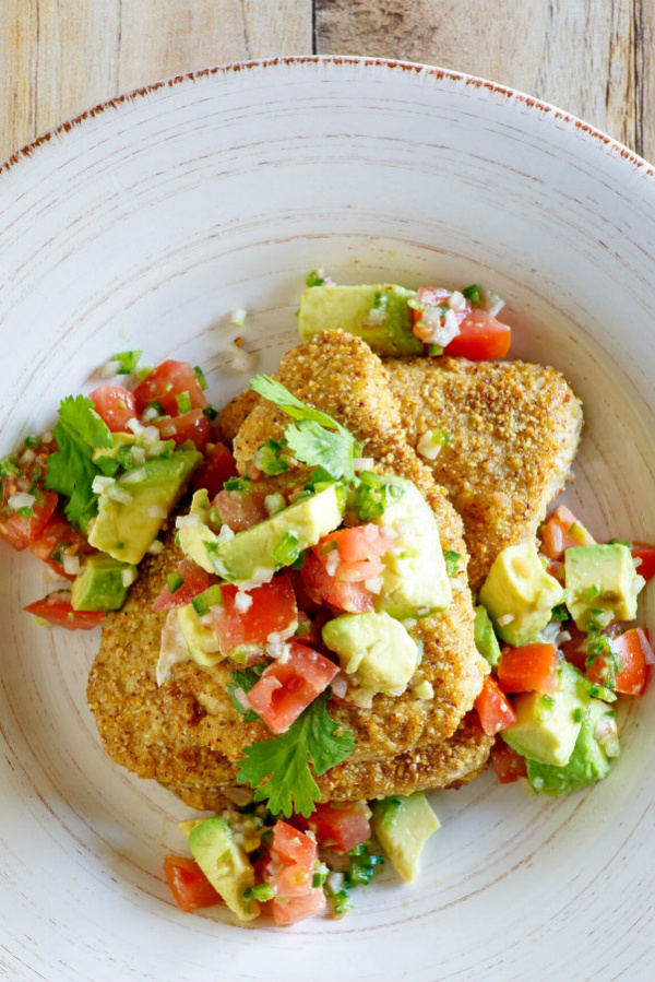 Tequila Almond Chicken on a plate topped with avocado and tomato salad