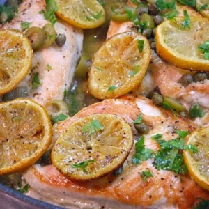 Sauteed Chicken with Olives, Capers and Roasted Lemons on a white plate