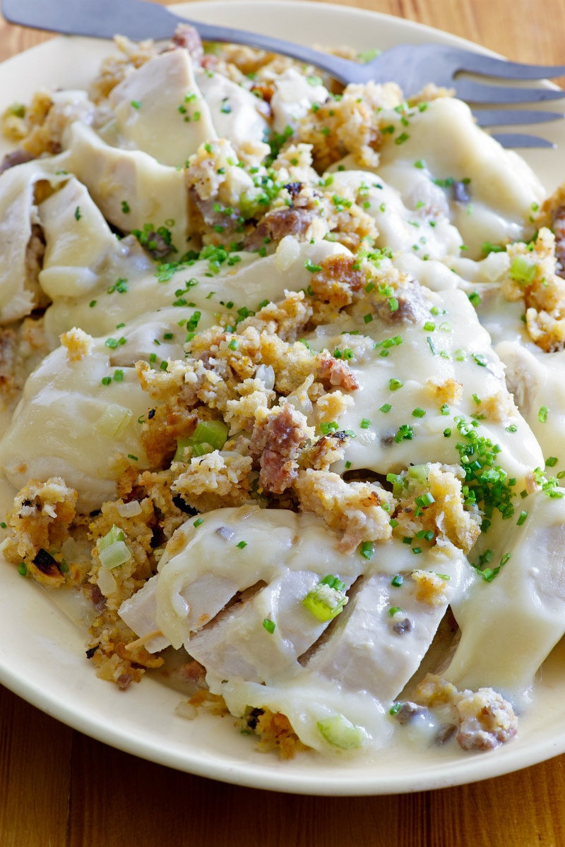 Swiss Chicken Casserole recipe from RecipeGirl.com #swiss #chicken #casserole #recipe #RecipeGirl Swiss Chicken Casserole on a white platter with a serving fork