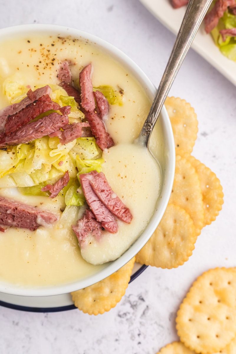 spoon in a bowl of corned beef and cabbage soup