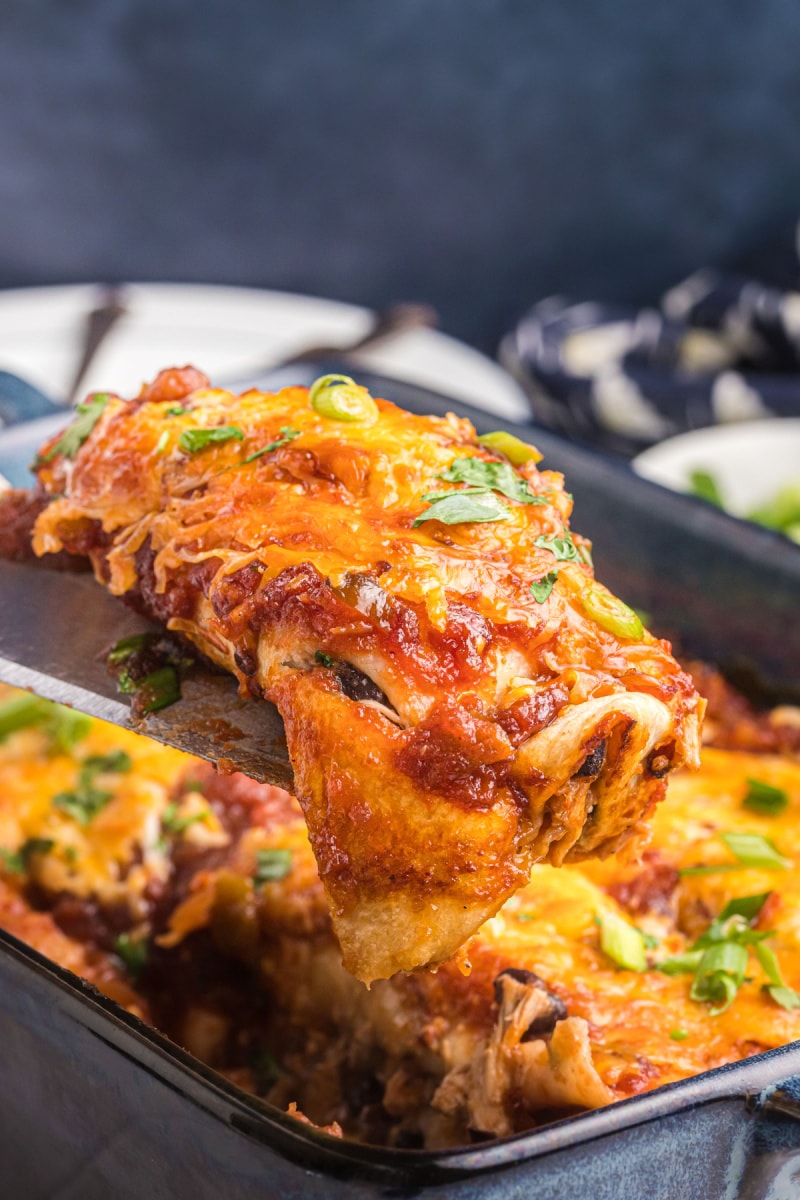 dishing out a cranberry turkey enchilada from pan