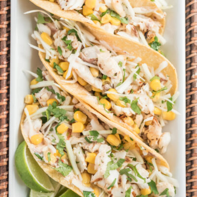 fish tacos on a platter with lime wedges