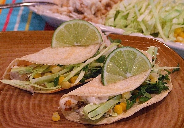 two Fish Tacos with Chipotle Cream topped with lime wedges