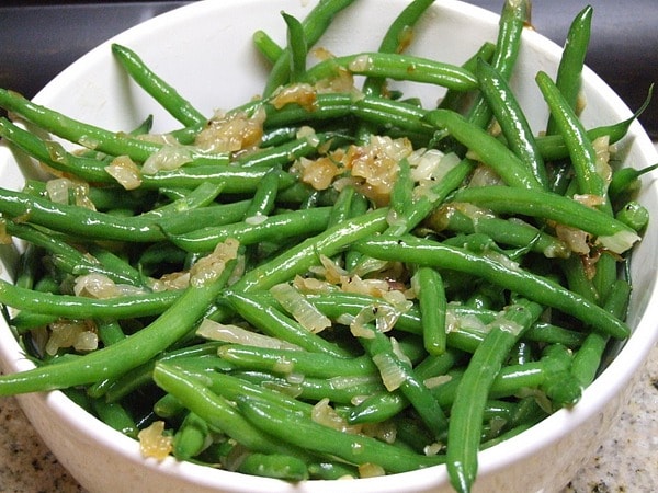 white bowl with green beans and caramelized shallots