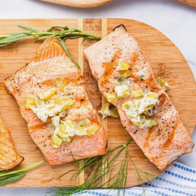 two grilled salmon fillets topped with dill pickle butter