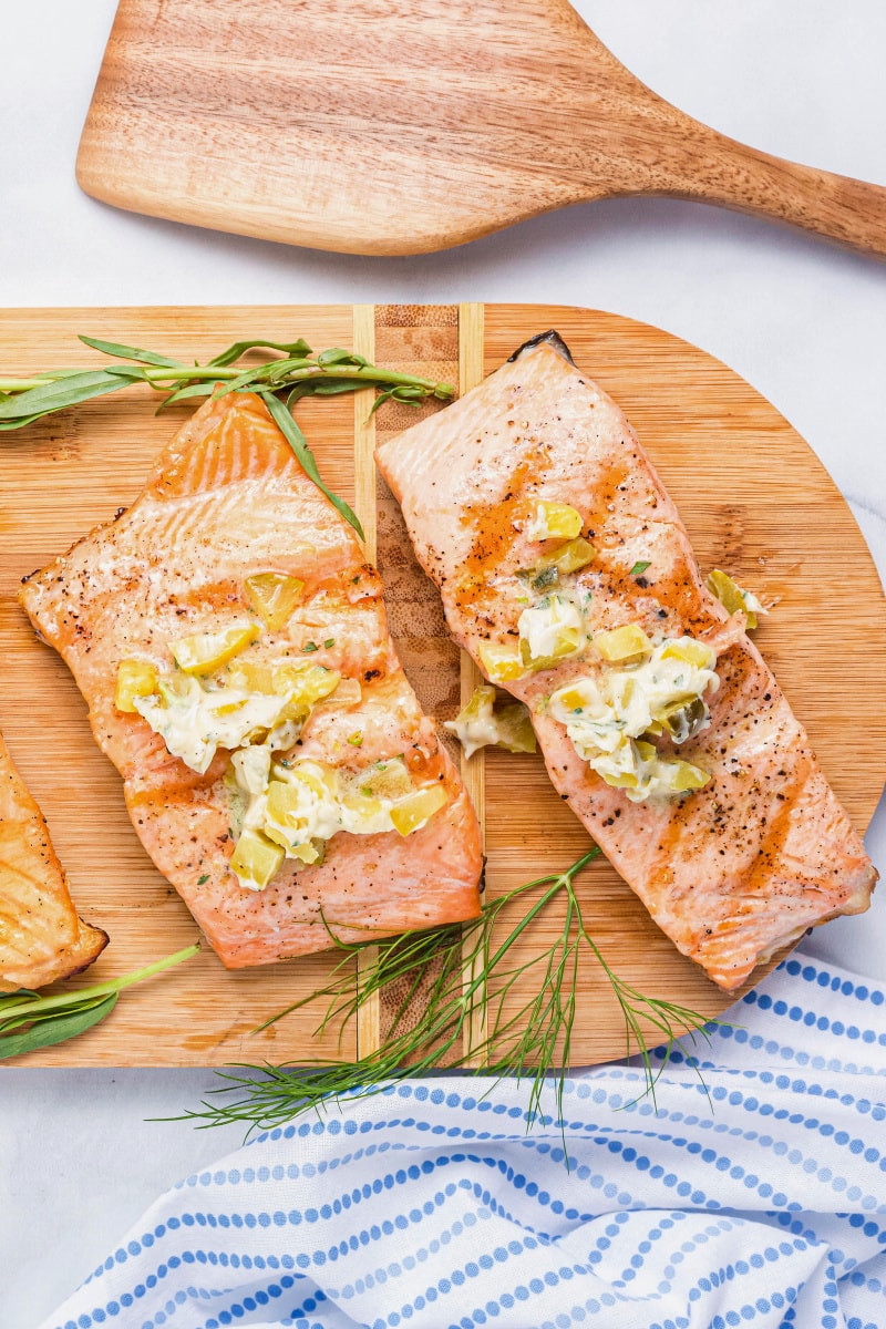 two grilled salmon fillets topped with dill pickle butter