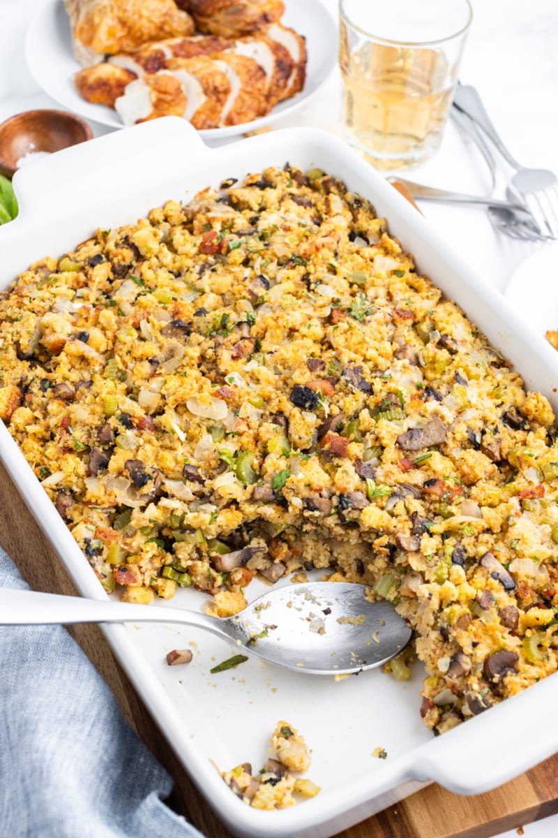 spooning stuffing out of casserole dish