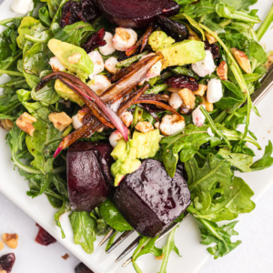 beet and goat cheese arugula salad on plate