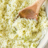 wooden spoon in a bowl of coconut ginger rice