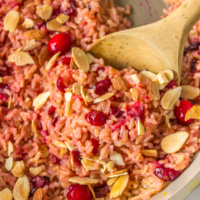 wooden spoon in pot of cranberry rice pilaf