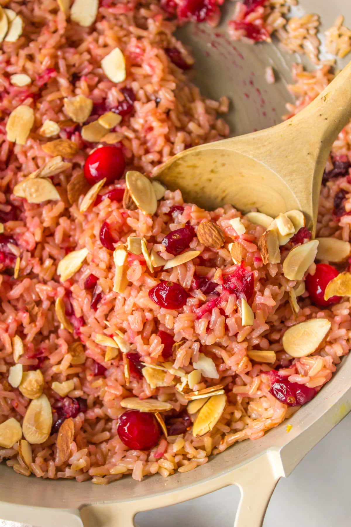 wooden spoon in pot of cranberry rice pilaf