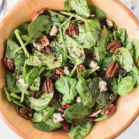 cranberry spinach salad in wood bowl