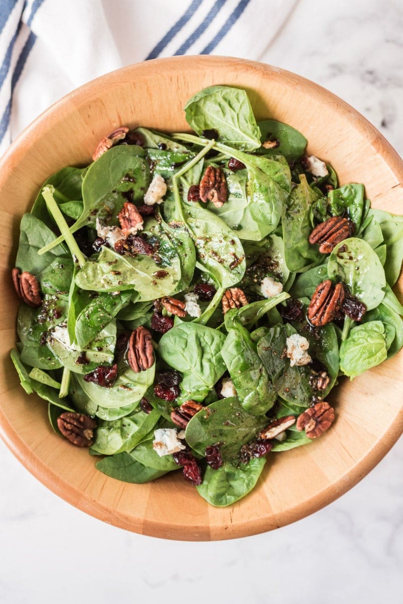 cranberry spinach salad in wood bowl