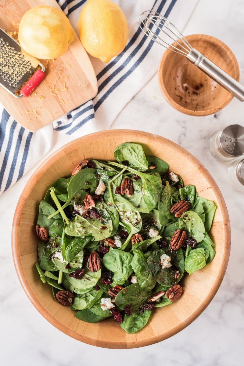 cranberry spinach salad in wooden bowl