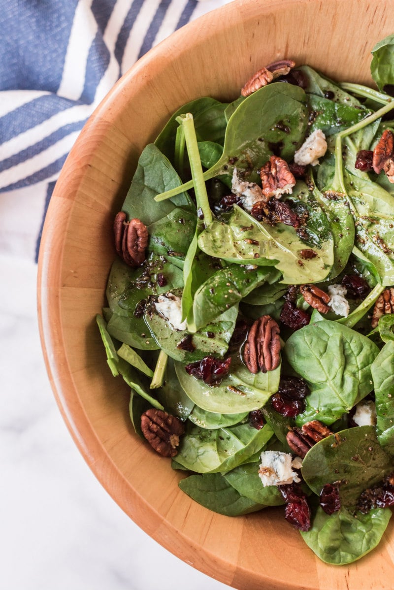 cranberry spinach salad in wooden bowl