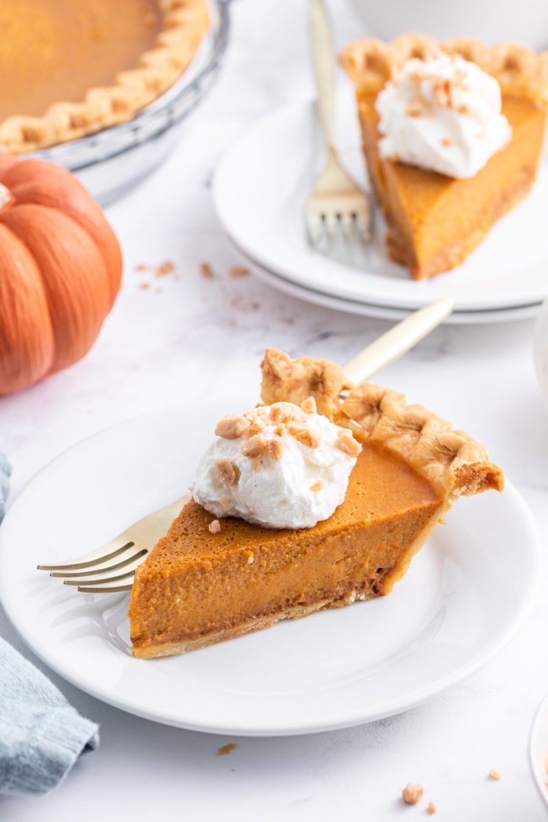 slice of dulce de leche pumpkin toffee pie on a plate topped with whipped cream