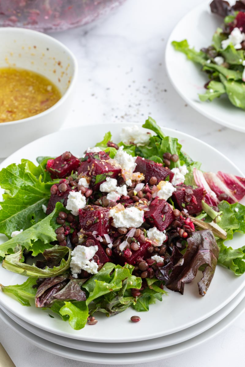 french lentil and roasted beet salad on a plate with greens