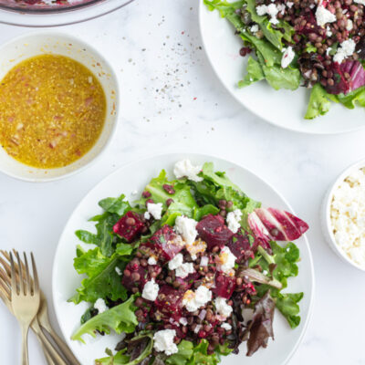 two plates of french lentil and roasted beet salad over greens