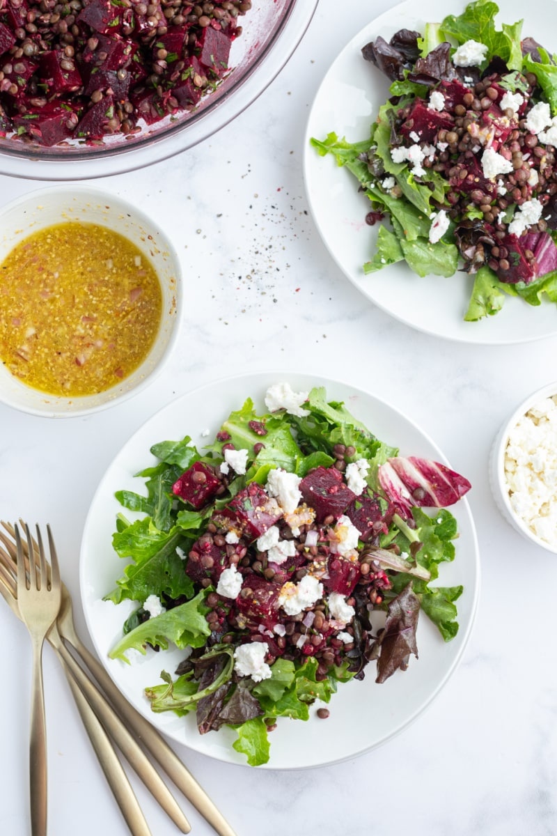 two plates of french lentil and roasted beet salad over greens