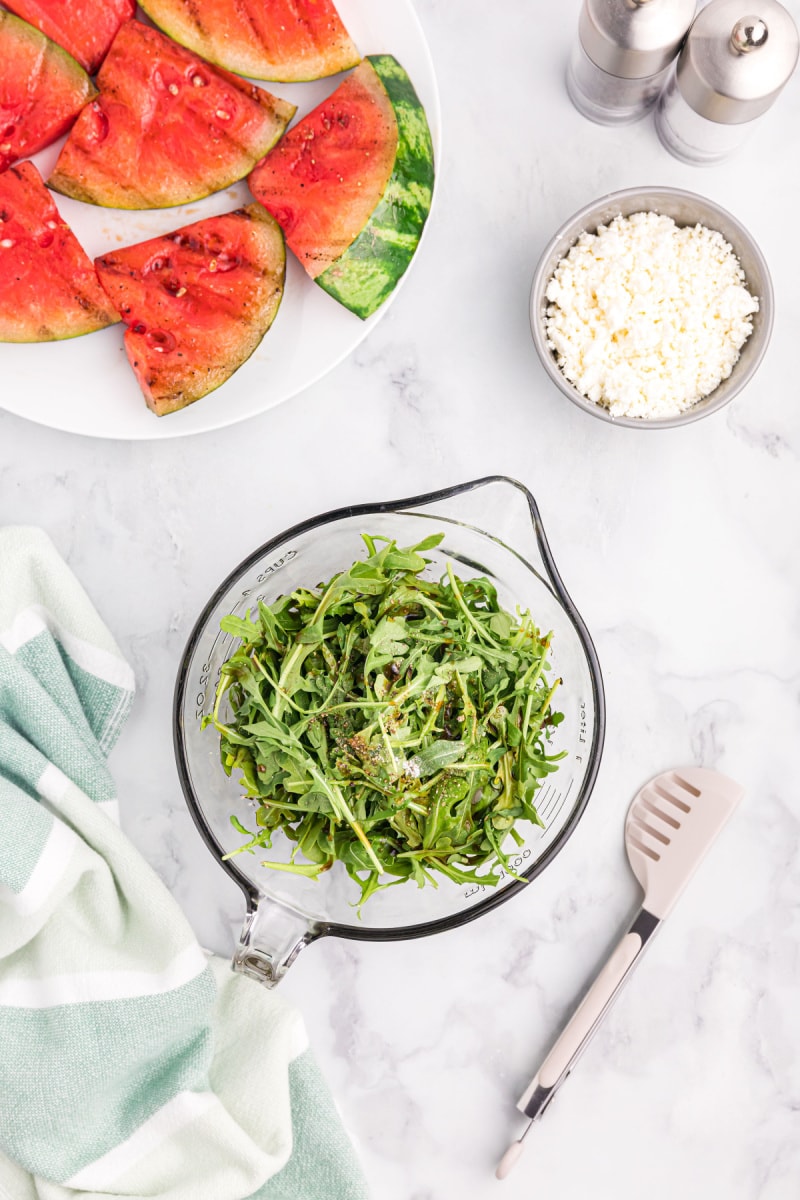 tossed greens in a measuring cup